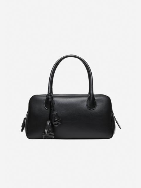 Brigitte in black leather with flower charm