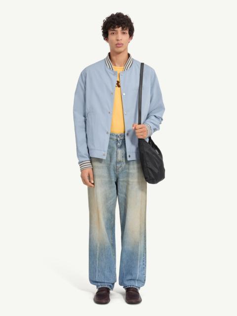 A classic varsity silhouette refined through a softened structure. The jacket balances utilitarian c