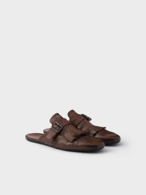 Shuffle antiqued leather mules with buckled strap and fringe