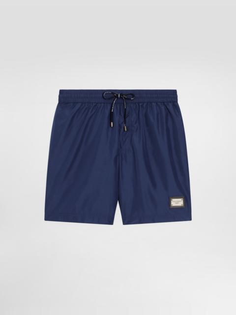 Mid-length swim trunks with branded plate