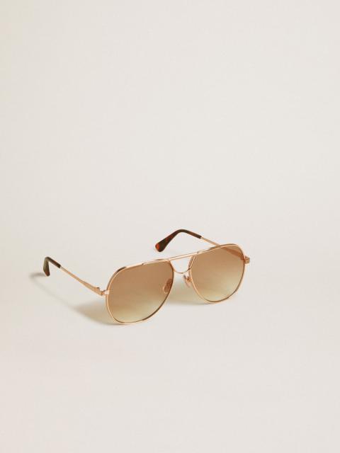 Aviator style sunglasses with rose-gold frame and honey-colored lenses