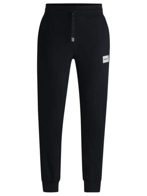 TRACKSUIT BOTTOMS WITH METALLIC LOGO LABEL