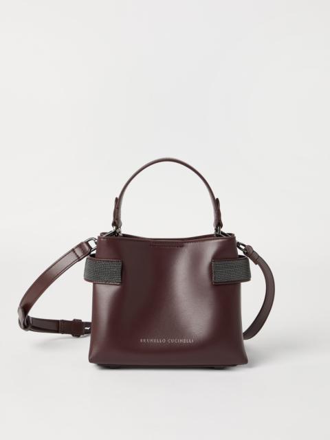 Essence small top-handle bag in calfskin with precious bands