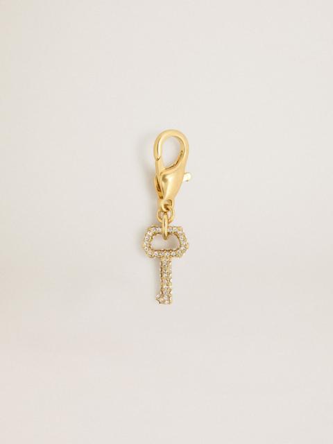 Key-shaped charm in gold-colored brass with crystals