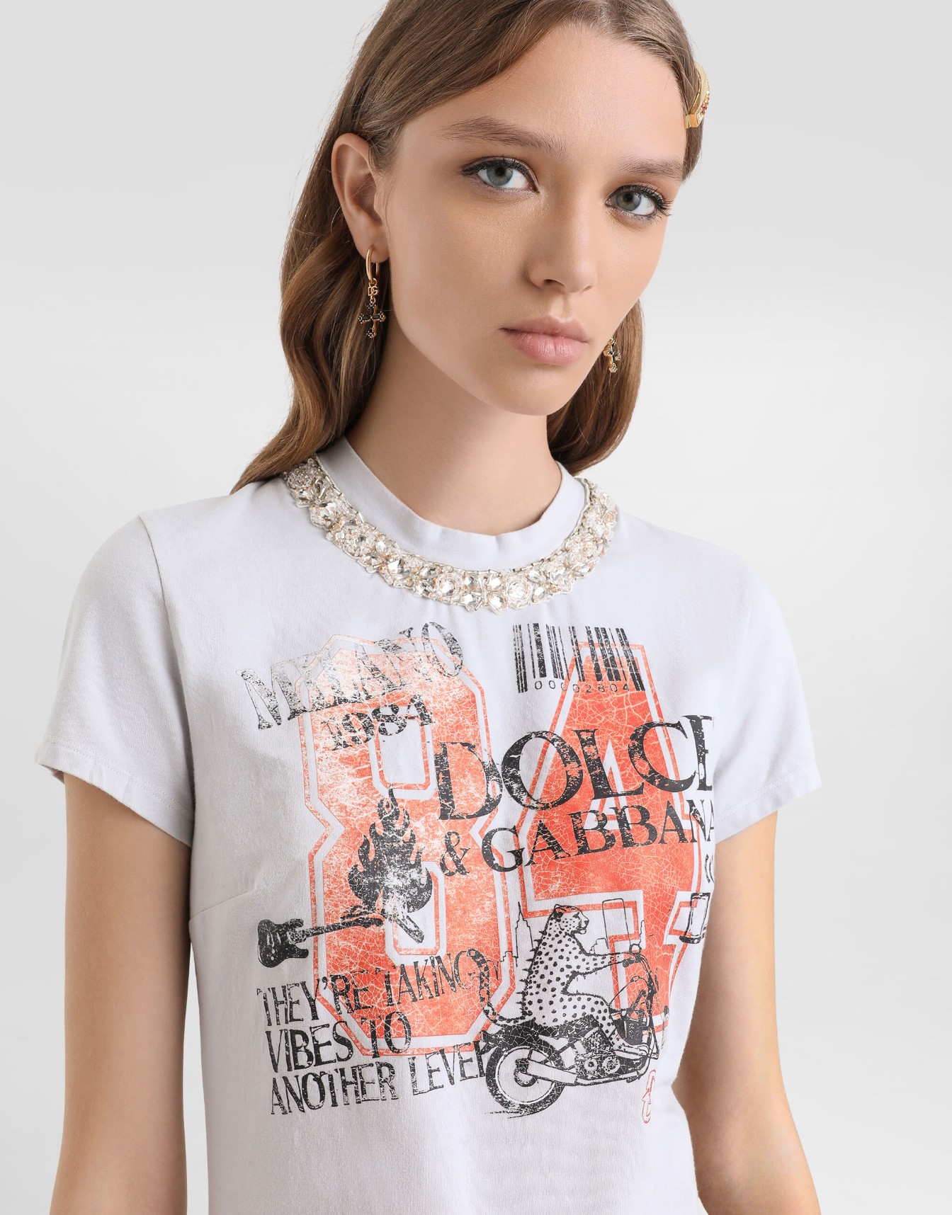 A casual graphic T-shirt with crystal embellishments and printed detailing.