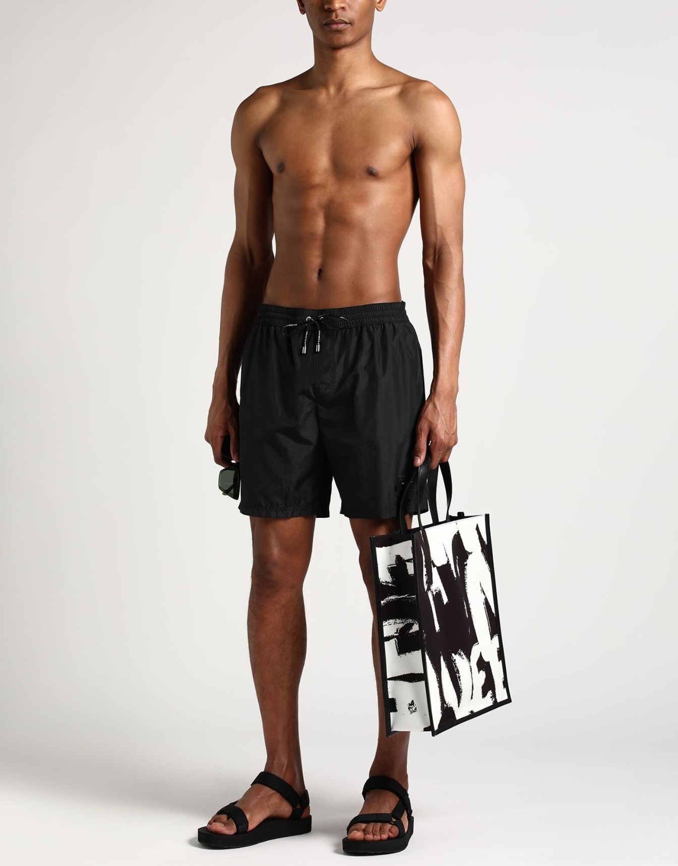 Men's mid-length designer swim trunks featuring a branded logo tag.