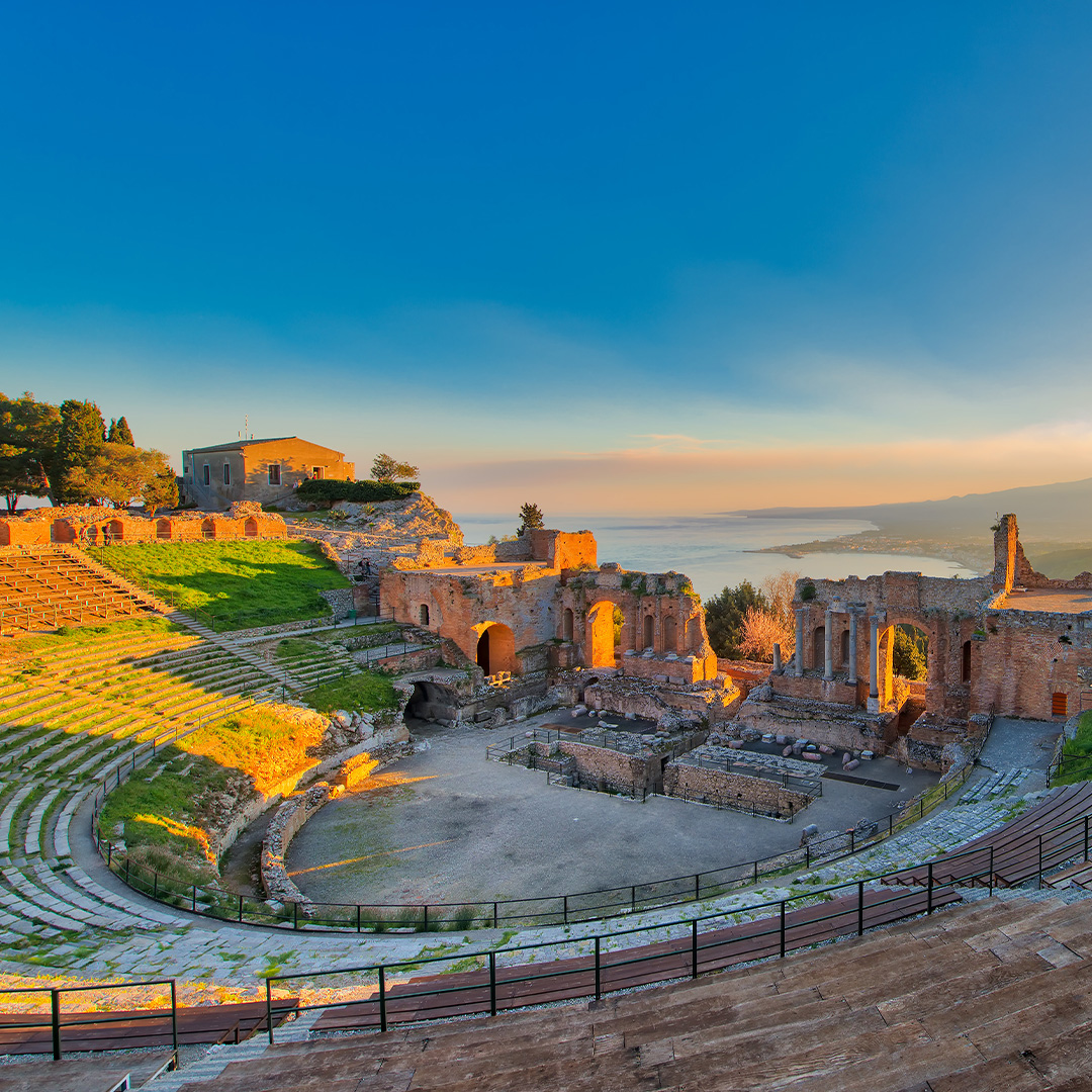 The scenic coastal town of Taormina, Sicily, showcasing winding historical alleys and citrus trees that inspire Dolce & Gabbana collections.
